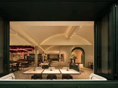 A restaurant dining area with multiple tables and chairs, creating an inviting atmosphere for socializing and enjoying meals together