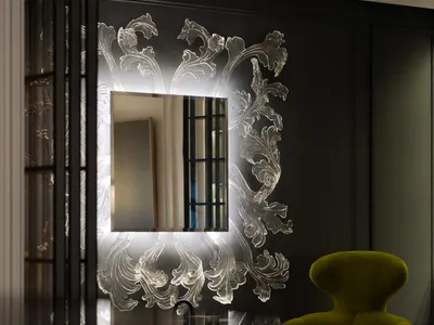 A modern living area with a green chair and ornate mirror, set against a black wall