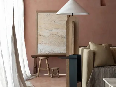 Cozy living space with a rug, couch, chair, and lamp, featuring brick walls and warm lighting