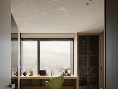 Cozy modern bedroom with a green bed near a large window offering a city view, surrounded by books and a chair