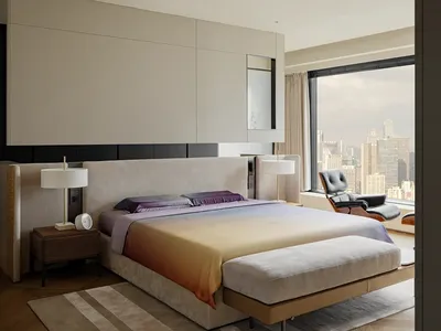 A large bedroom with a king size bed, two chairs, and a couch, featuring a window for natural light and a clean, organized appearance