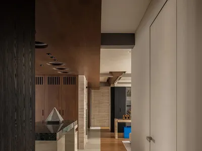 Modern kitchen with wooden walls, a sink, cabinets, dining table, and chair, featuring ample storage and a functional design