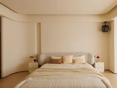 A cozy bedroom with a large white bed on a beige carpet, lit by two lamps, creating a relaxing atmosphere
