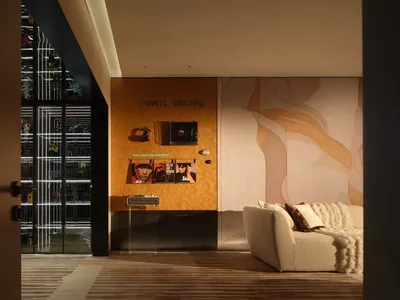 Comfortable living space with a hardwood floor, a couch, a chair, and a TV, surrounded by books and records