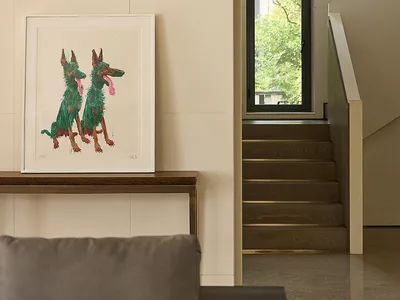 A warm and inviting living area with a wooden floor, featuring a painted dog mural and a framed dog painting, creating a cozy atmosphere