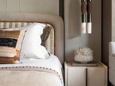 A cozy hotel bedroom with a large bed, white bedding, and wooden paneling on the walls