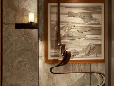 Cozy bathroom with a brown tile wall, a picture hanging on it, and two lights, creating a warm and inviting atmosphere