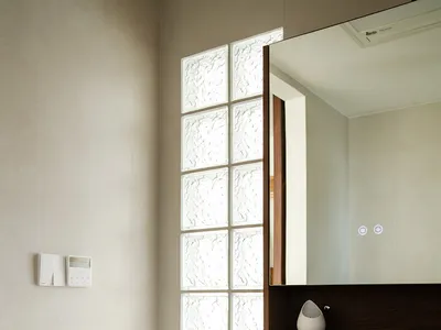 Bathroom with a white sink, mirror, and window, featuring a clean and well-lit atmosphere