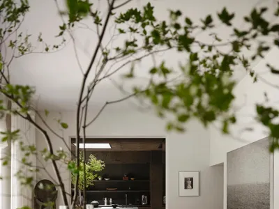 Cozy living room with a grey color scheme, a couch, dining table, chairs, and natural light from a large window