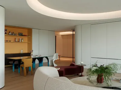 Cozy open concept living space with a dining table, chairs, a couch, and a potted plant, featuring inviting and warm atmosphere