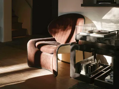 A modern living area with a brown leather chair in front of a white wall, accompanied by decorative bottles, conveying a sense of comfort and sophistication