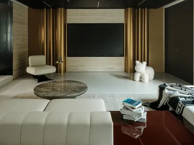 Cozy living space with a flat screen TV, two chairs, a couch, and a dining table, with a teddy bear on the floor