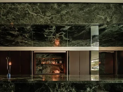 Elegant kitchen with a large marble countertop, bottles on the counter, and a sophisticated atmosphere