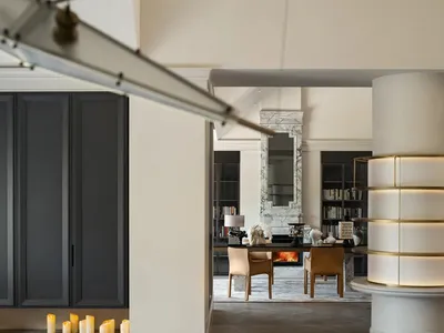 Cozy open concept living space with a dining table, chairs, and scattered books, featuring a warm and inviting atmosphere