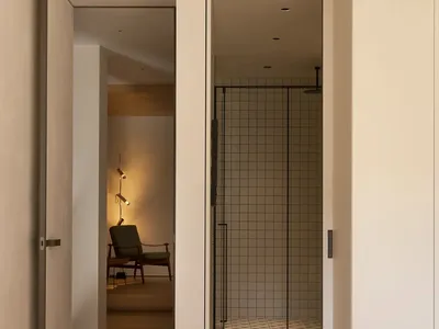Cozy bedroom with a large white doorway, two chairs, and a couch, creating a comfortable seating arrangement