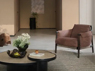 Empty living room with a brown chair, two potted plants, and three apples, creating a calm and inviting atmosphere