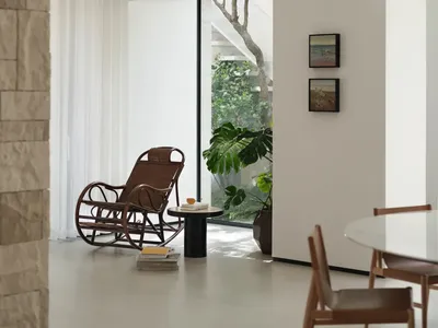 溫馨客廳區域，白色室內設計，木質與金屬家具、餐桌、盆栽與散落書籍