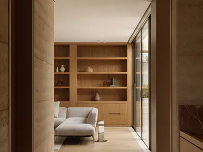 Cozy open concept living space with a wooden bookshelf, a brown couch, and a warm atmosphere