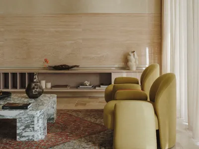 Coastal living space with a yellow chair in front of a window, a dining table, books, and decorative vases