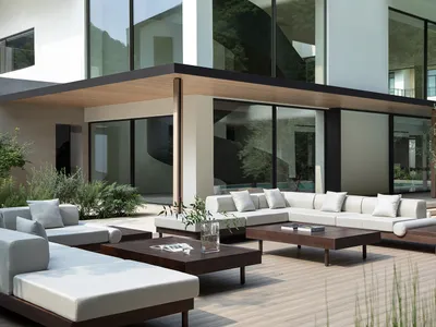 Comfortable indoor living area with a white couch, glass door, chairs, dining table, and potted plants