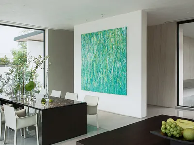 Elegant dining space with a large painting, wine glasses, and a dining table surrounded by chairs