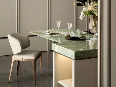 Elegant dining room with gray walls, a dining table, chairs, wine glasses, and a vase with flowers