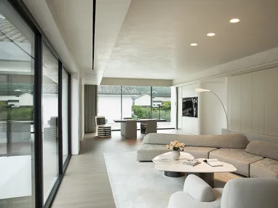 A bright and inviting living area with a couch, chairs, dining table, and decorative vase, surrounded by natural light from a window