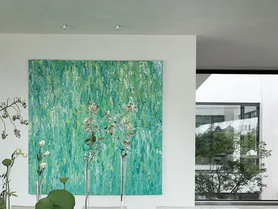 溫馨餐廳空間，包含餐桌、椅子、花瓶插花、盆栽植物，以及牆上的畫作