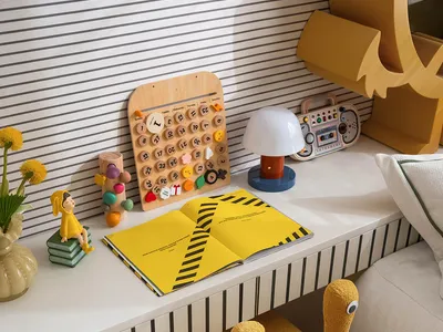 A child's bedroom with a yellow chair, desk, books, toys, and vases, creating a cozy atmosphere