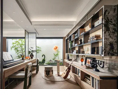 Cozy living room with hardwood floors, white walls, and a piano, featuring furniture, books, and potted plants, well-lit and inviting