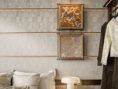 A modern bedroom with a bed, dresser, and artwork on the walls, featuring neutral tones and good lighting