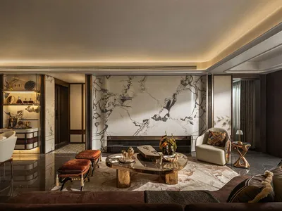 Luxurious living room with a marble floor, a large couch, chairs, and dining tables, complemented by a decorative vase