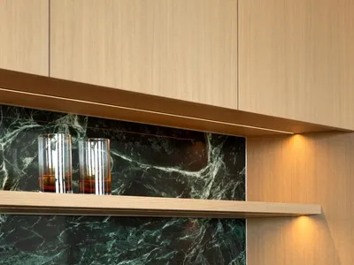 A kitchen with a marble countertop, whiskey bottle, and two wine glasses, creating an elegant and sophisticated atmosphere