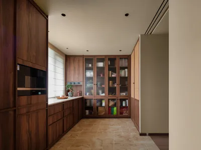Clean and organized kitchen with wooden cabinets, tile flooring, and various kitchen items on display