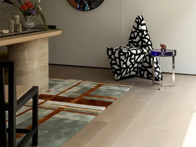 Cozy modern living space with a chair, dining table, couch, and vases, featuring a large wall clock and wooden furniture