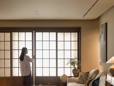 舒適客廳空間，白色沙發、椅子、餐桌與盆栽，透過開放門戶灑入自然光線