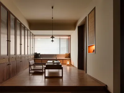 Warm and inviting open living area with wooden floors and walls, featuring a dining table, chairs, and a potted plant