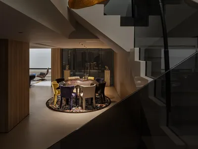 A well-lit living area with a dining table, chairs, and vases, exuding a warm and inviting ambiance