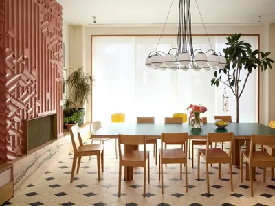A dining area with a wooden table and chairs, surrounded by potted plants, creating a cozy atmosphere