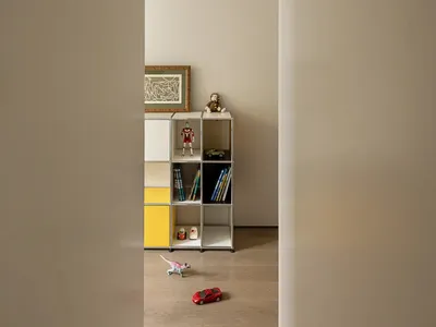 Cozy child's bedroom with a wooden floor, toys, books, and a teddy bear, creating a playful and inviting atmosphere