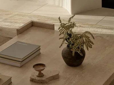 A cozy living area with a dining table, books, and a vase with flowers, creating a warm and inviting atmosphere