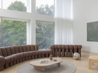 Inviting open concept living area with a couch, chairs, and dining table, featuring a book and cozy atmosphere