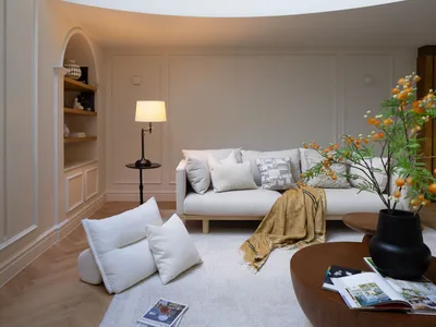 A bright and inviting open concept living area with a white couch, two chairs, a dining table, and a potted plant, emphasizing comfort and functionality