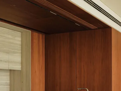 Modern kitchen with wooden cabinets, marble countertops, two sinks, and a warm inviting atmosphere