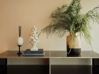 Cozy living space with a wooden table, vases, a plant, a book, and an egg, set in a warm and inviting atmosphere