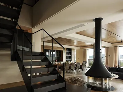 Warm and inviting living room with a large fireplace, chairs, and a dining table, surrounded by cozy atmosphere
