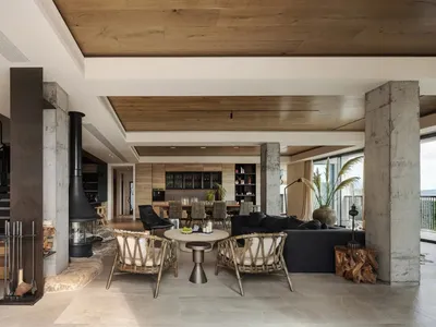 Warm and inviting open concept living area with a large fireplace, wooden floors and walls, and various decorative elements