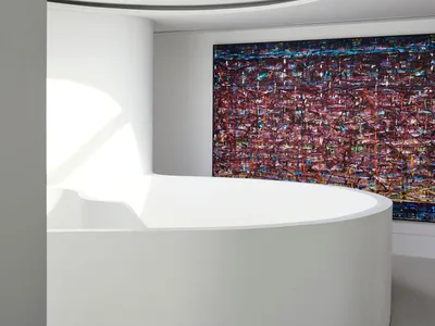 A contemporary living area with a large white wall featuring a vibrant red modern art piece, adding a bold touch to the space