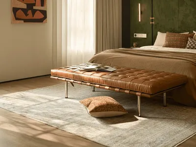 Cozy bedroom with a bed, bench, and painting, featuring wood and fabric materials, soft natural lighting, and a focus on relaxation