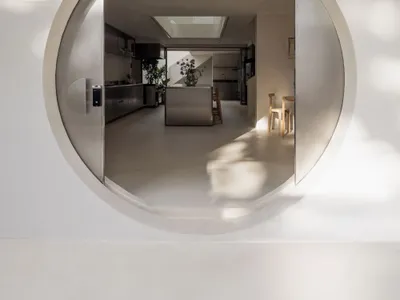 一間現代式廚房和餐廳區域，配備洗碗櫃、冰箱、微波爐、餐桌、椅子、花盆和花瓶，透過大窗戶自然光照明